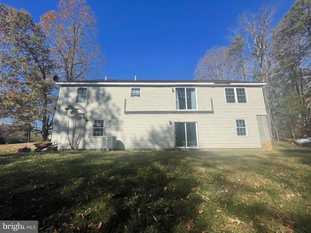 back of house with a lawn and central air condition unit