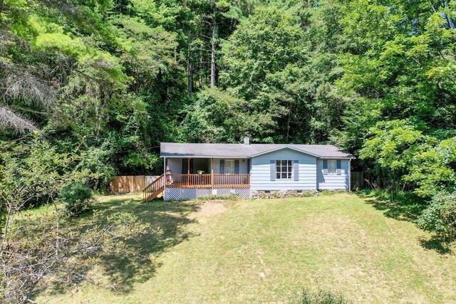 view of front of home with a wooden deck and a front yard