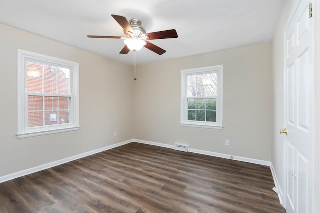 unfurnished room with dark wood-style floors, baseboards, visible vents, and ceiling fan