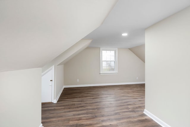 bonus room featuring lofted ceiling, baseboards, and dark wood-type flooring