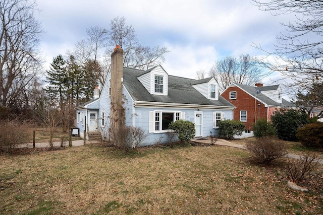 cape cod home featuring entry steps, a chimney, and a front yard