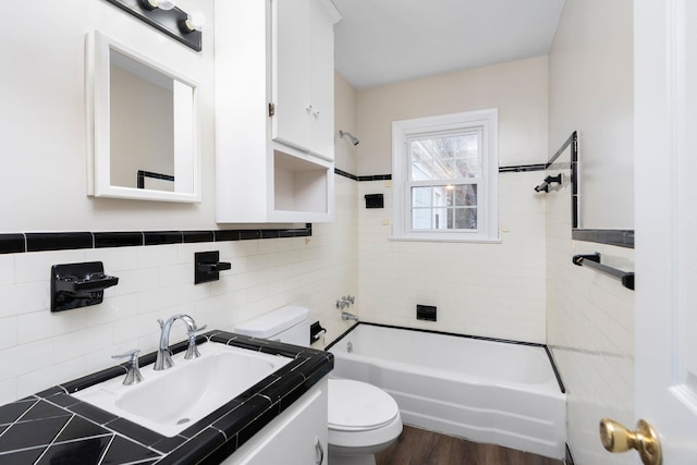 full bath featuring a wainscoted wall, tile walls, toilet, vanity, and wood finished floors