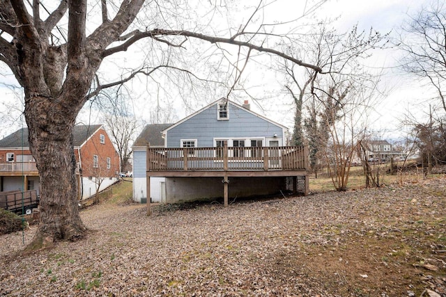 rear view of property with a chimney and a deck