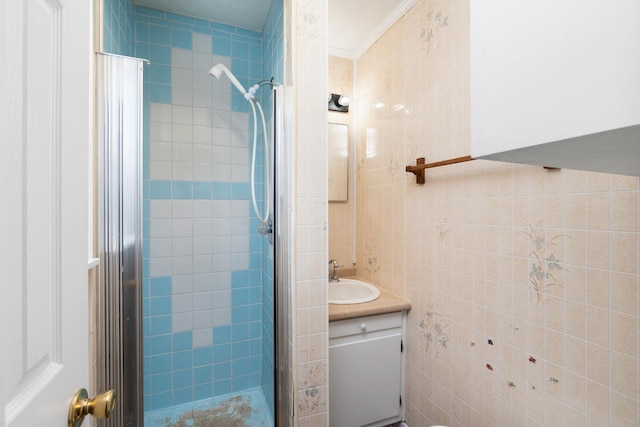 full bathroom with a stall shower, tile walls, and vanity