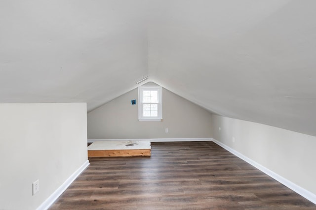 additional living space featuring lofted ceiling, dark wood finished floors, and baseboards