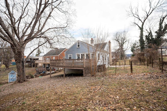 rear view of house with a chimney and a deck