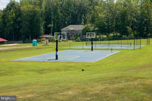 view of sport court featuring tennis court and a lawn