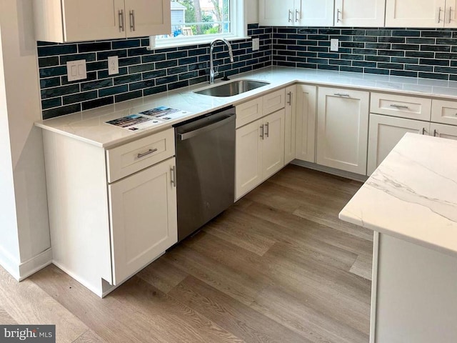 kitchen featuring white cabinetry, stainless steel dishwasher, sink, and light wood-type flooring