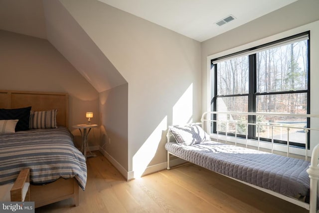 bedroom with light hardwood / wood-style flooring and vaulted ceiling