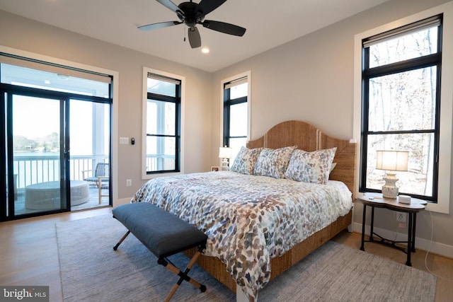 bedroom with multiple windows, hardwood / wood-style flooring, and access to exterior