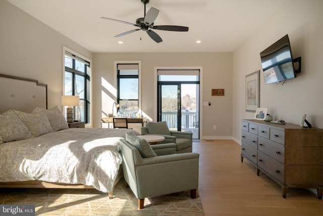 bedroom featuring ceiling fan, light hardwood / wood-style flooring, multiple windows, and access to outside