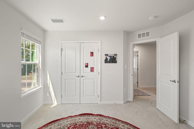 foyer featuring light carpet