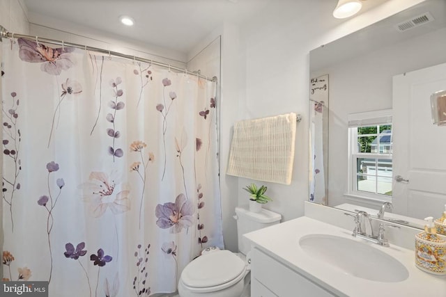 bathroom with vanity, curtained shower, and toilet