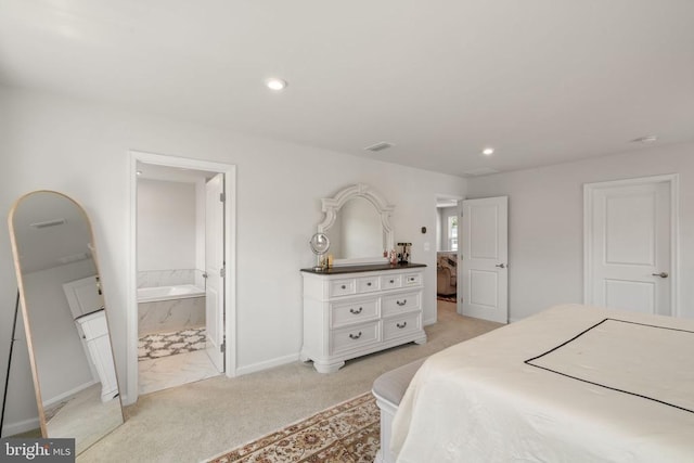 bedroom featuring ensuite bathroom and light carpet