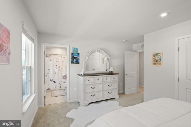 carpeted bedroom featuring ensuite bath