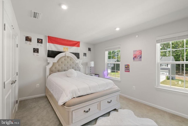 carpeted bedroom featuring multiple windows