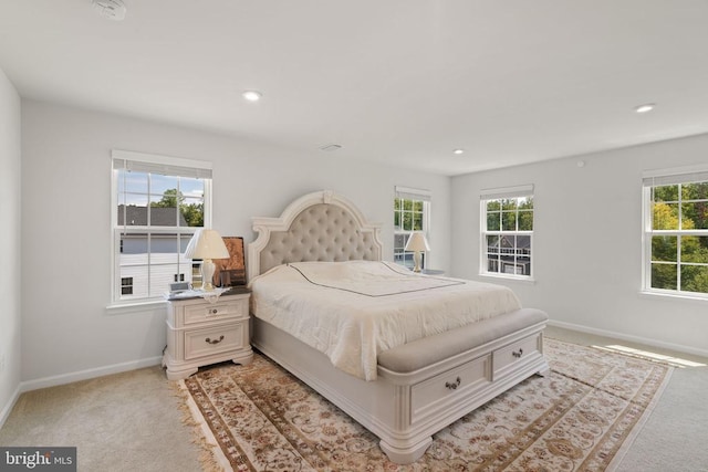 bedroom featuring multiple windows and light colored carpet