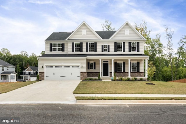 view of front facade featuring a garage, a front yard, and covered porch