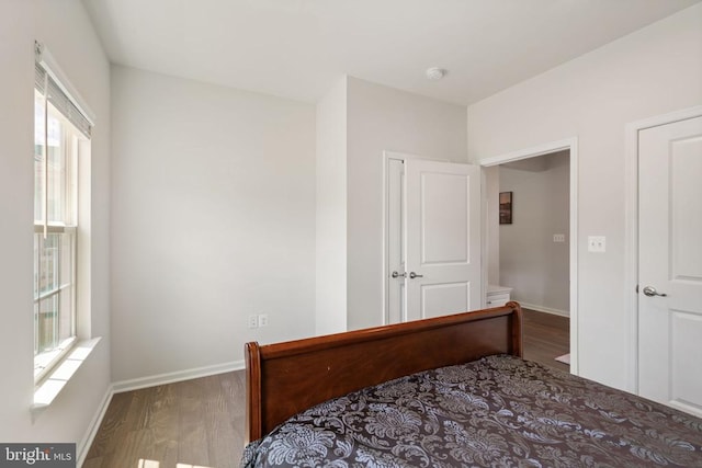 bedroom with dark hardwood / wood-style floors