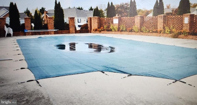 view of swimming pool featuring fence