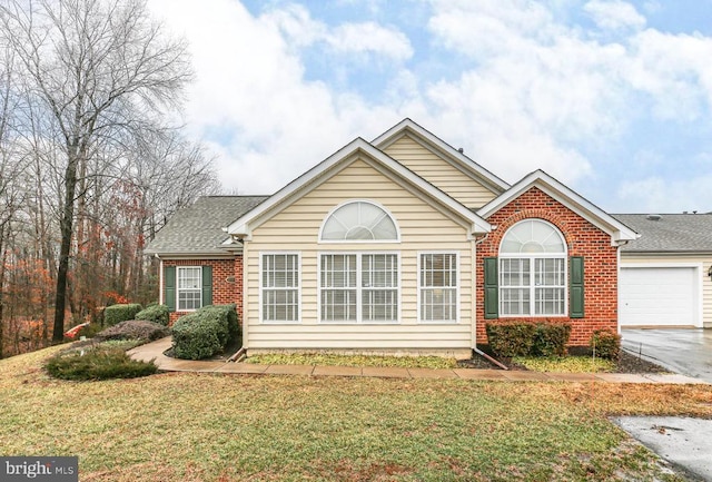 view of front of property with a garage, brick siding, a front yard, and a shingled roof