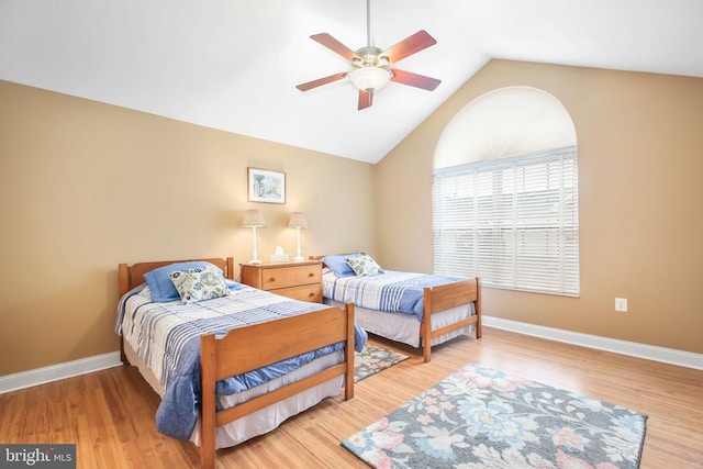 bedroom with lofted ceiling, baseboards, light wood finished floors, and ceiling fan