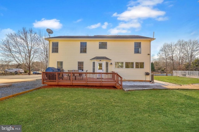 rear view of house featuring a yard and a wooden deck