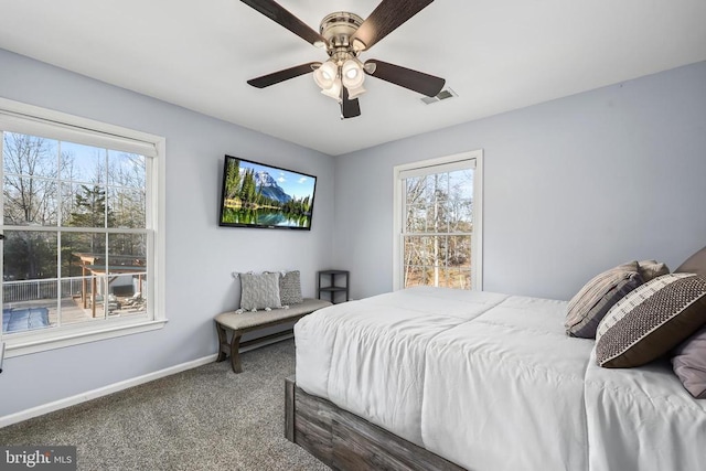 carpeted bedroom featuring a ceiling fan, visible vents, and baseboards