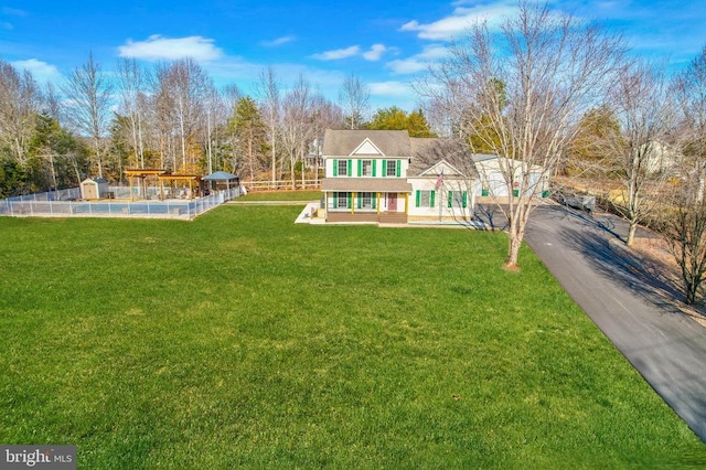 view of front facade featuring a front yard and fence