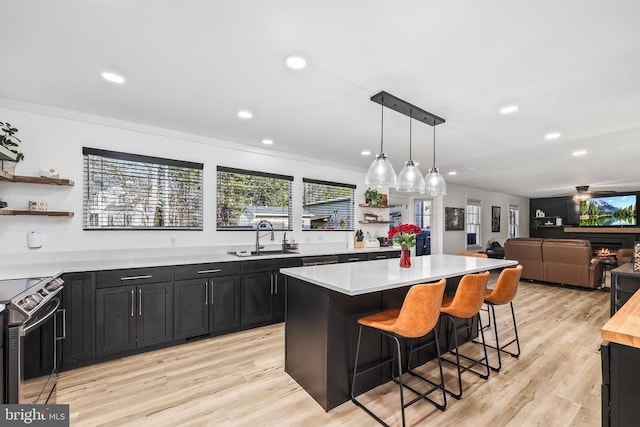 kitchen with dark cabinets, a sink, light countertops, stainless steel electric range, and open shelves