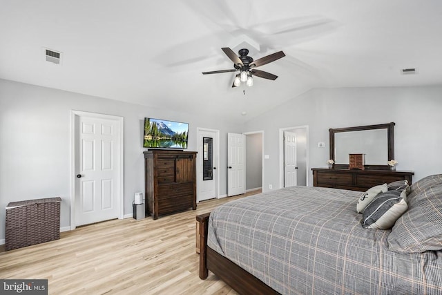 bedroom featuring lofted ceiling, light wood-style floors, visible vents, and a ceiling fan