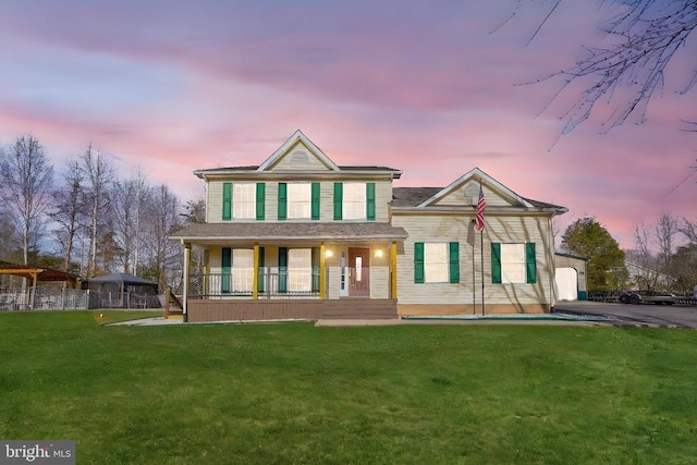 view of front of home featuring covered porch and a yard