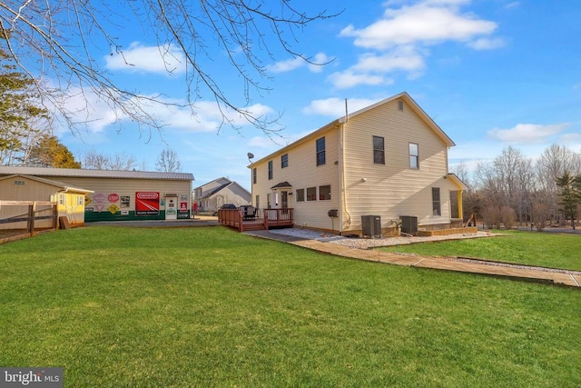 rear view of house with a yard, cooling unit, a wooden deck, and fence