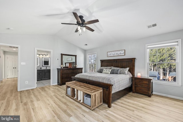 bedroom with light wood-style flooring, visible vents, vaulted ceiling, and baseboards