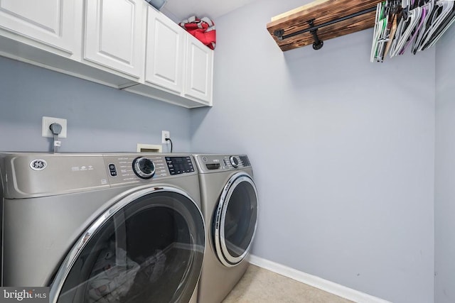 laundry area with washer and clothes dryer, cabinet space, and baseboards