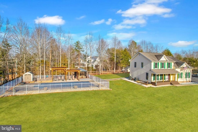 view of yard with an outbuilding, a fenced backyard, a shed, and a pergola