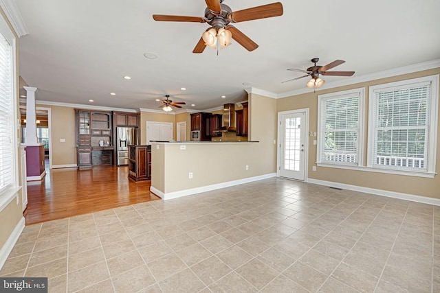 unfurnished living room with baseboards, light tile patterned flooring, ceiling fan, and crown molding