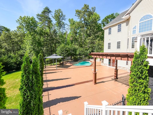 pool with a patio area and fence