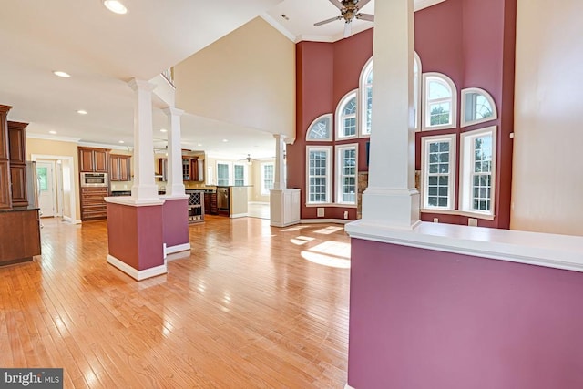 kitchen with open floor plan, a ceiling fan, ornate columns, and ornamental molding