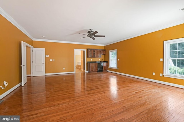 unfurnished living room featuring light wood finished floors, baseboards, crown molding, and ceiling fan