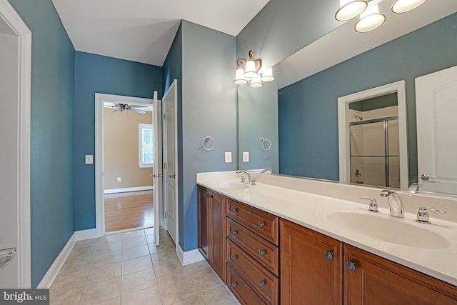 bathroom with tile patterned flooring, a shower stall, double vanity, and a sink