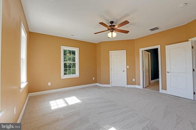 unfurnished bedroom featuring a ceiling fan, light colored carpet, visible vents, and baseboards