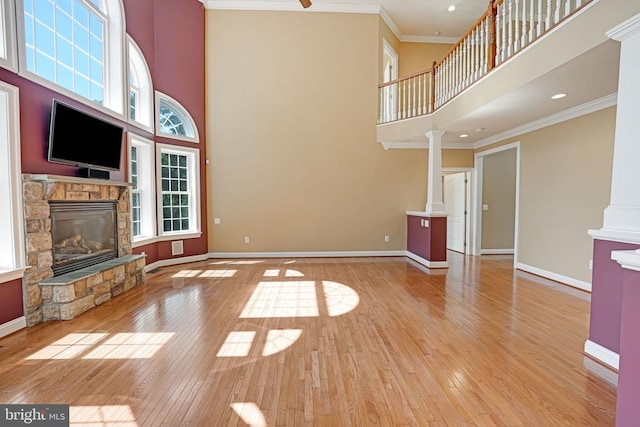 unfurnished living room with a fireplace, hardwood / wood-style floors, baseboards, and ornamental molding