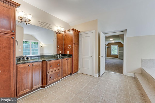 full bath featuring a sink, tile patterned floors, double vanity, and vaulted ceiling