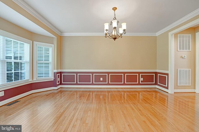 unfurnished room with visible vents, an inviting chandelier, and ornamental molding