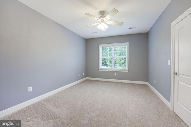 spare room with visible vents, light carpet, baseboards, and a ceiling fan