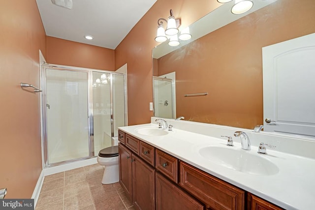 bathroom featuring tile patterned floors, toilet, a stall shower, and a sink