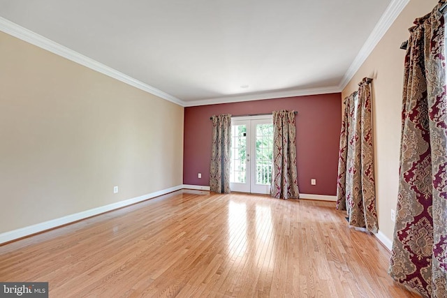 spare room featuring crown molding, light wood-style flooring, french doors, and baseboards