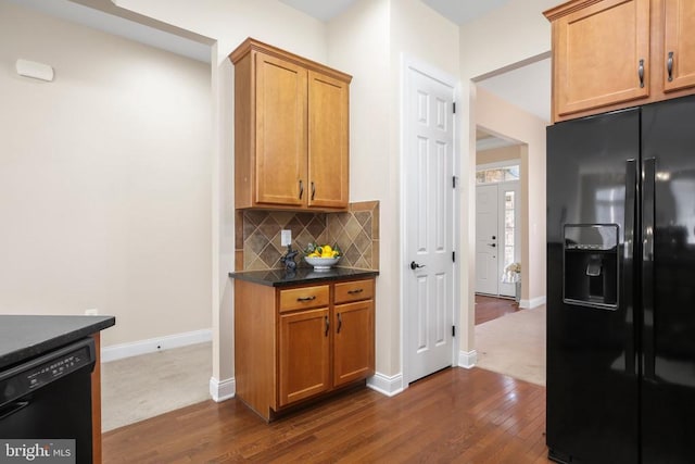 kitchen featuring backsplash, dark hardwood / wood-style floors, and black appliances