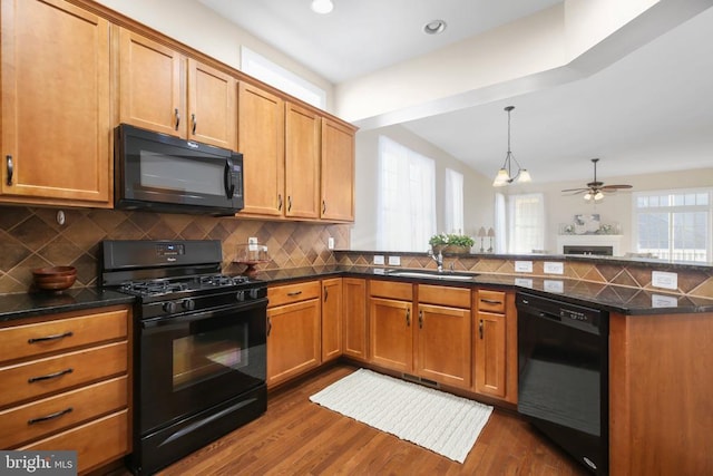 kitchen with dark wood-type flooring, sink, decorative backsplash, and black appliances